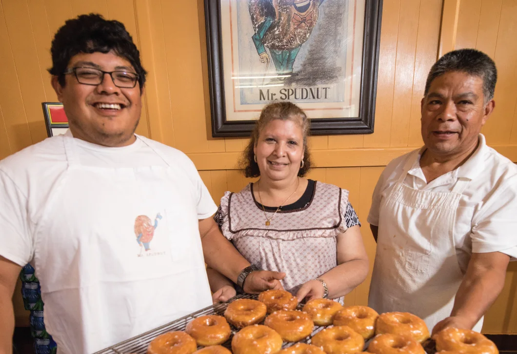 El equipo de Spudnuts en El Dorado junto a una bandeja de donas.