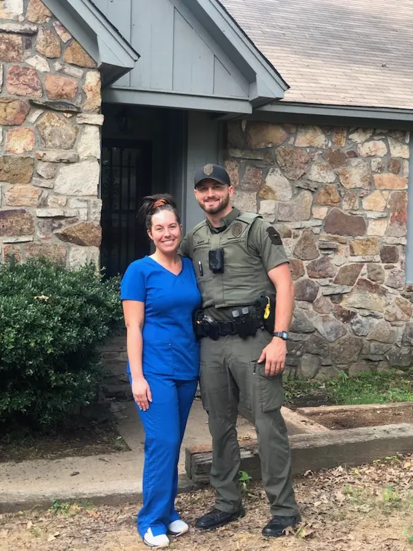 Couple standing in front of their home